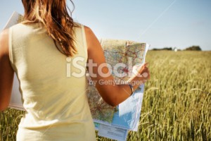 stock-photo-12893208-rear-view-of-a-lady-with-road-map-in-field